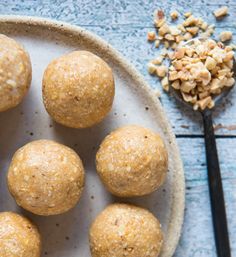 several balls of food on a plate next to a spoon and oatmeal