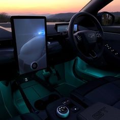 the interior of a car is lit up with blue lights and features an electronic touch screen