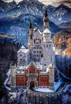 an aerial view of a castle with mountains in the background and snow on the ground