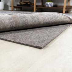 a close up of a rug on the floor in a room with shelves and furniture