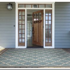 the front door of a house with a black and white rug