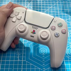 a close up of a person holding a nintendo wii game controller in their left hand