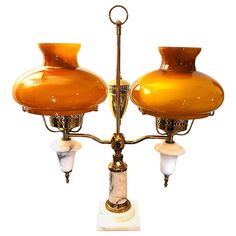 an orange and white table lamp with two lamps on it's sides next to each other