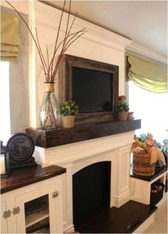 a living room with a fireplace and tv on top of the mantel above it