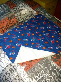 a blue and red quilt on top of a bed with numbers all over it's surface