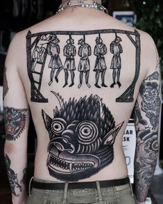 the back of a man's body with tattoos on it