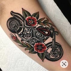 a tattoo with a motorcycle and flowers on it