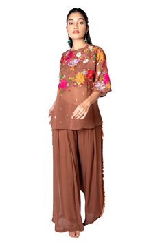 Brown short tunic with floral embroidered bodice and sequin work. Paired with embroidered stripe flared pant and bustier.
Component: 3
Embroidered
Neckline: Round
Sleeve Length: Three quarter
Fabric: Georgette, Raw Silk
Color: Brown
Sequin work - Aza Fashions Embroidered Georgette Pant Set, Floral Embroidery Pant Set For Eid Party, Eid Party Pant Set With Floral Embroidery, Party Georgette Tops With Floral Embroidery, Party Tops With Floral Embroidery In Georgette, Party Tops With Floral Embroidery On Georgette, Festive Embroidered Georgette Tops, Festive Embroidered Tunic Top, Embroidered Anarkali Georgette Top