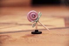 a pink lollipop sitting on top of a wooden table