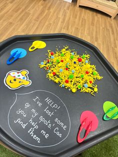 a child's play tray with writing on it and various toys sitting on the floor