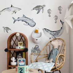 a child's room with dolphin decals on the wall and a rocking chair