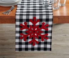 a black and white checkered table runner with a red snowflake on it