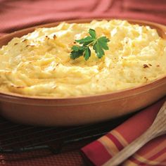 a bowl filled with mashed potatoes and garnished with parsley