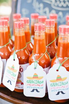 several bottles of hot sauce with tags on them