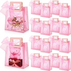 12 pink gift bags with teddy bear and flowers in them, all lined up on top of each other