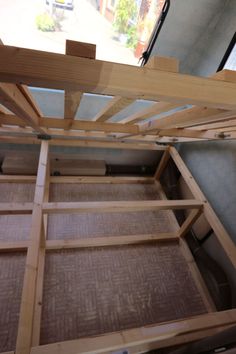 the bottom half of a bed frame is being constructed into a small room with no mattresses