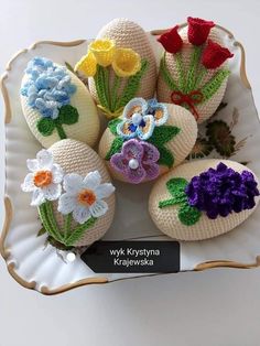 crocheted eggs with flowers are on a plate