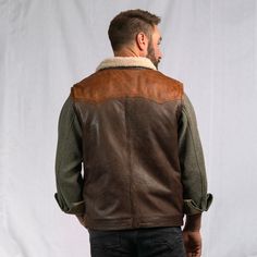 Our iconic western vest was inspired by the high mountain valleys of the Bison State. Built with a quality and craftsmanship worthy of our brand and our name. The open-arm Western Yoke exterior features 100% full grain lambskin leather, secured by a top-to-bottom antique nickel zipper with optional button-down flap and framed by twin front side pockets. Our sherpa-style polyester interior lining extends through the classic fold over collar… providing lasting comfort and mobility from the barn to Rugged Leather Vest Outerwear, Rugged Fall Vest Outerwear, Rugged Brown Vest Outerwear, Outdoor Leather Vest With Pockets, Rugged Brown Winter Vest, Brown Rugged Winter Vest, Brown Rugged Vest For Winter, Leather Winter Outdoor Vest, Leather Sleeveless Winter Vest