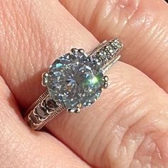 a woman's hand with a ring on it and a diamond in the middle