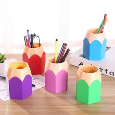 colorful pencils and pens are sitting in vases on a table next to books