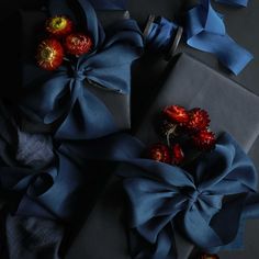 blue wrapping paper with flowers and ribbon around it on top of a black tablecloth