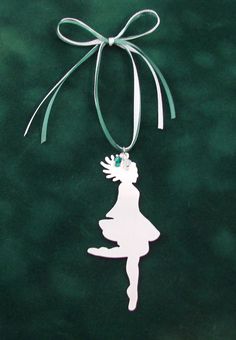 an ornament hanging from the side of a green bag with a white silhouette of a girl