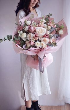 a woman holding a bouquet of flowers in her hands