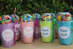 there are many cups with candy in them and thank you written on the top one