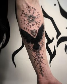 a person with a tattoo on their arm that has an eagle and compass in it