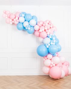 a balloon arch with pink, blue and white balloons