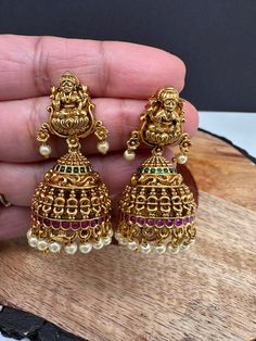 Goddess Lakshmi Matte Jhumkis screwback earringsColor : GoldenSize : Length : 1.75 Inches; Weight : 13 grams eachStones : Red Green Stones Pearls Goddess Lakshmi, Traditional Earrings, Social Events, Green Stone, Indian Jewelry, Red Green, Stone, Green, Red