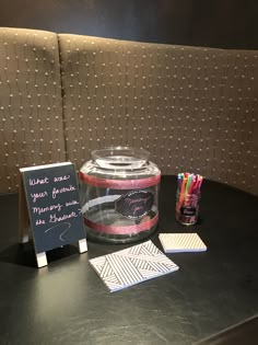 a table topped with a glass jar filled with candy and writing on it's side