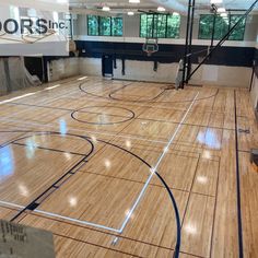 an indoor basketball court with hard wood flooring and blue trim on the sidelines