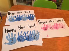 three handprinted new year cards sitting on top of a table