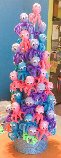 there is a very colorful tree made out of plastic eyeballs and hair clips on the table