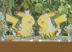 two pikachu figurines sitting on top of a table