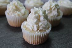 several cupcakes with white frosting on a table