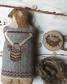 a wooden doll next to a bird nest