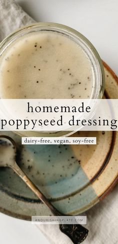 homemade poppy seed dressing in a glass jar on a plate with a spoon next to it