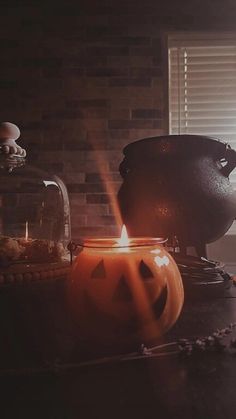 a candle is lit in front of two caulders with jack - o'- lanterns on them