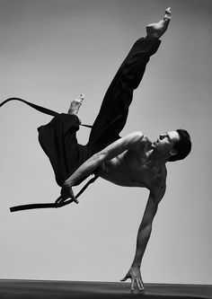 a man doing a handstand on top of a floor with his leg in the air