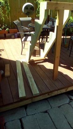 an outdoor table and chairs on a wooden deck