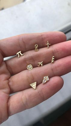 a person holding five different types of rings in their hand, all with letters and symbols on them