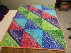 a multicolored quilt sitting on top of a bed