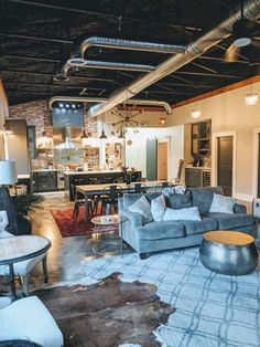 a living room filled with furniture and lots of lights hanging from the ceiling above it