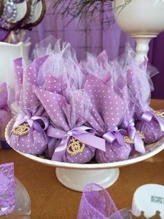 there are many purple candies in the bowl on the table with decorations around it