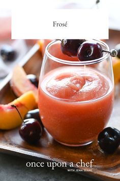 a glass filled with liquid next to fruit