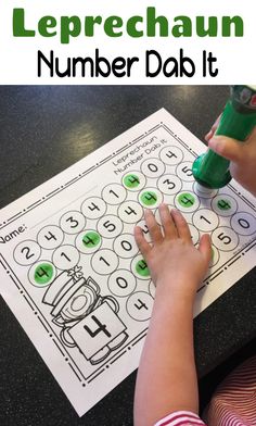 a young child is working on a number dab it game with the words leprechaun