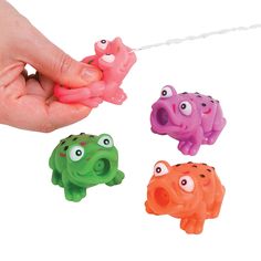 a hand is pulling three small toy animals on a string with two eyes and one nose