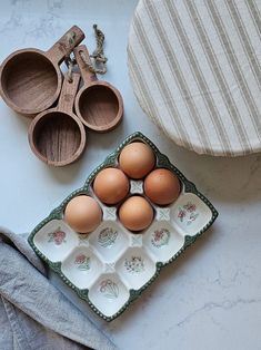 an assortment of eggs in trays next to kitchen utensils